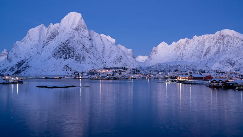 Snötäckta berg vid en sjöstad